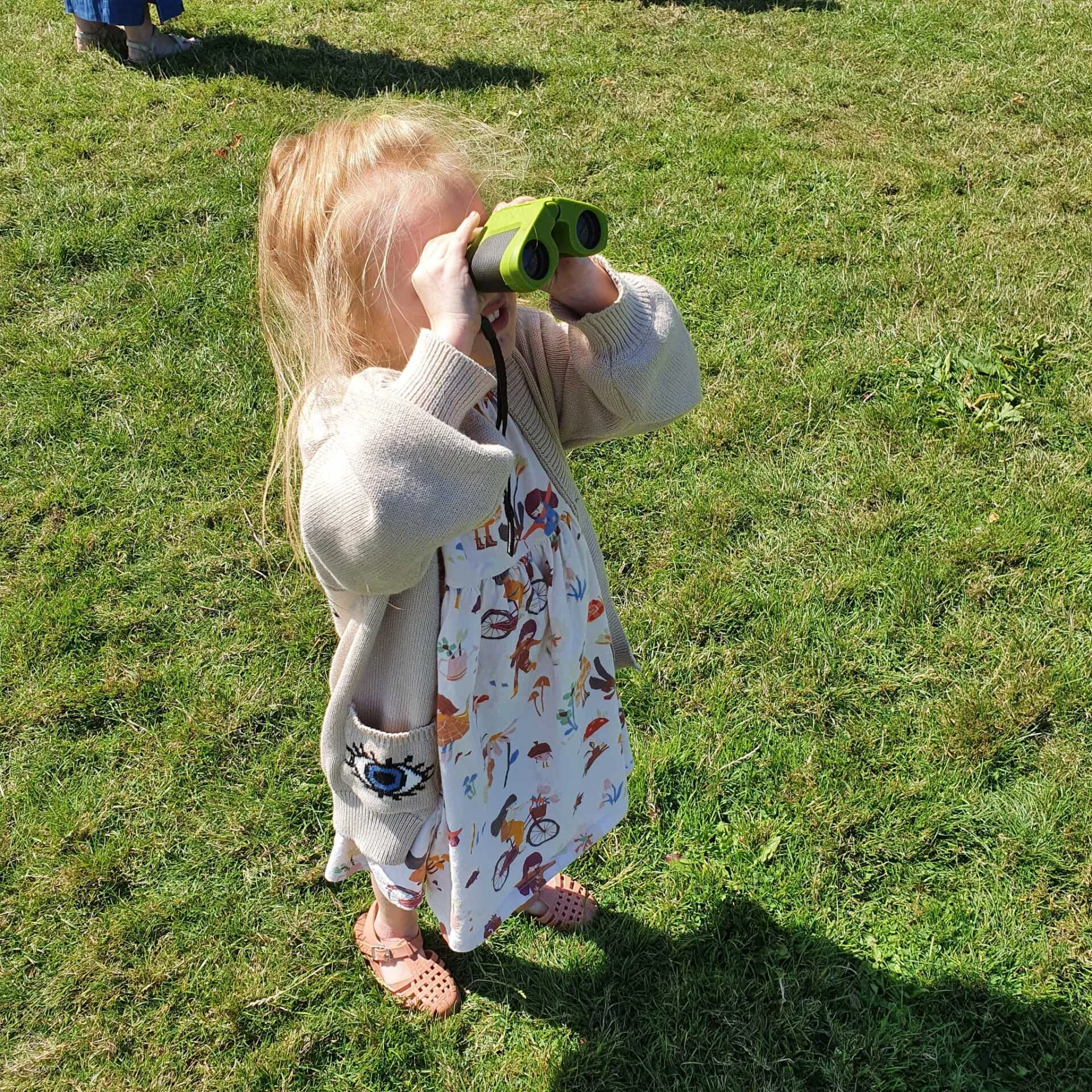 A child looking through binoculars in the garden