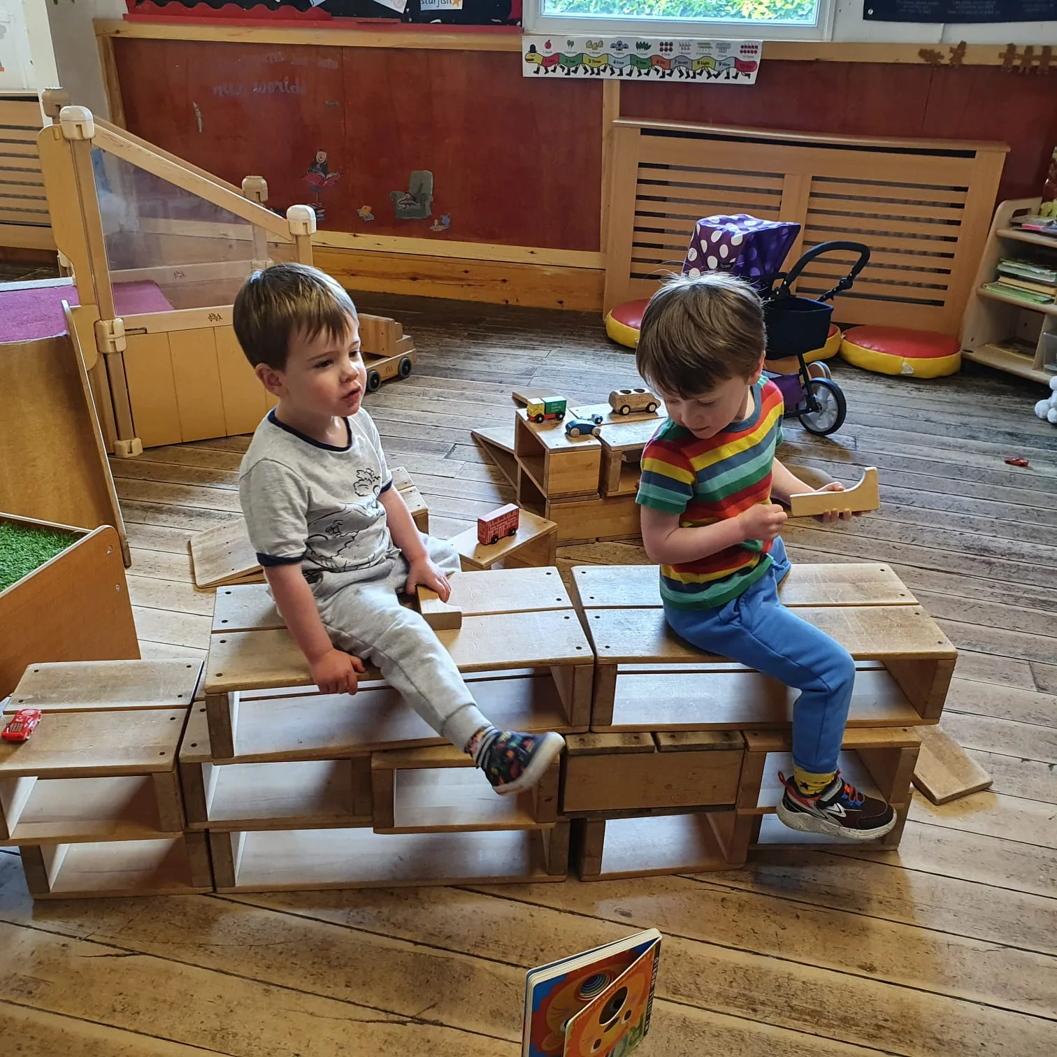 Two Riverside children building together with wooden blocks